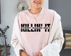 a woman wearing a pink shirt with the words kill it every damn - day written on it