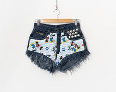 Unique reworked vintage Wrangler shorts - in navy blue with a Mickey Mouse pattern on the front - metal studs on the left pocket - cut-off and super frayed leg - 5 pockets - zip fly - materials: denim SIZE size from label: no label best fits women: S/M MEASUREMENTS waist: 27 inches (69 cm) hips: 37 inches (94 cm) rise: 10,5 inches (27 cm) CONDITION: Great condition. Small discoloration on the back - shown in the photos. Wrangler Shorts, Reworked Vintage, Vintage Wrangler, Graphic Top, Crochet Blouse, Vintage Skirt, Vintage Graphics, Short Outfits, Vintage Ladies