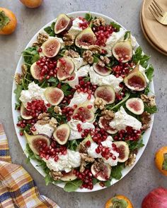 a white plate topped with salad covered in figs and goat cheese on top of lettuce