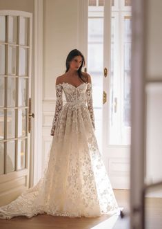 a woman in a wedding dress is standing by the door