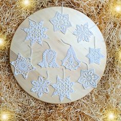 an ornament with snowflakes hanging from it's side on some straw