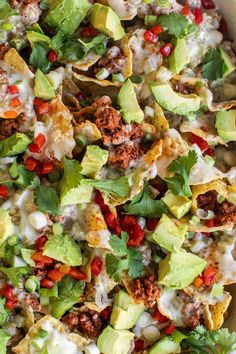 a white casserole dish filled with meat, cheese and veggie nachos