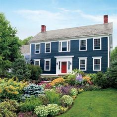 a blue house surrounded by lush green grass