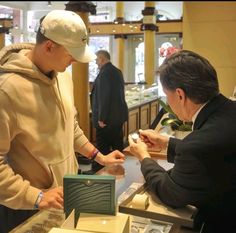 two men standing at a counter in a store