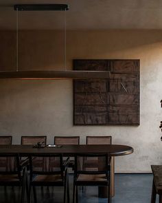 a table and chairs in a room with a painting on the wall behind it,