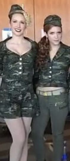 three women dressed in army uniforms posing for a photo