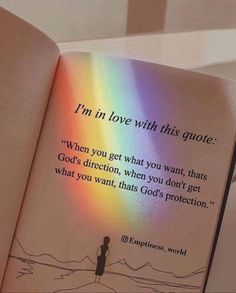 an open book with a rainbow light shining on the page and someone standing in front of it