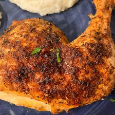 a close up of a chicken on a plate with mashed potatoes