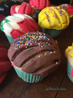 several cupcakes with frosting and sprinkles on them sitting on a table