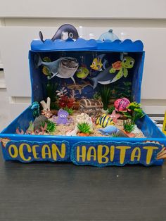 an ocean habitat with fish and other marine life in the bottom half, on top of a table