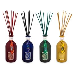 four different colored bottles with reeds in them