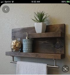 a wooden shelf with two towel racks and a potted plant on top of it