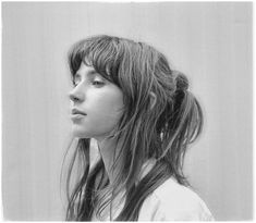 a black and white photo of a woman with long hair looking off to the side