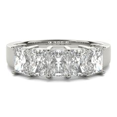 a white gold ring with three princess cut diamonds on the sides and four baguetts in