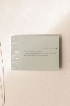 a close up of a business card on a bed with white sheets and pillows in the background