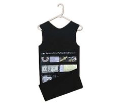 a black tank top hanging on a hanger with money in the pocket and other items inside it