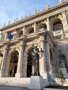 an ornate building with flags flying in the wind