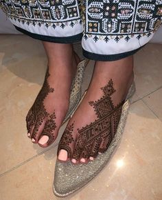 a woman's feet with hennap on them and her foot in sandals