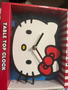 a hello kitty clock in a box with the time on it's face and hands