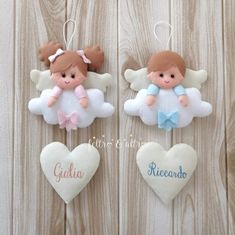 three angel ornaments hanging on a wooden wall