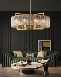 a living room with a couch, coffee table and chandelier hanging from the ceiling