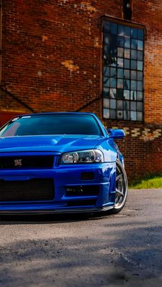 a blue car parked in front of a brick building