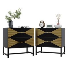 two black and gold dressers next to each other with an alarm clock on top