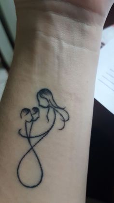 a woman's wrist with a small tattoo design on her left arm and the word love written in black ink