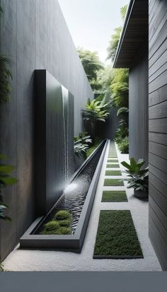 an outdoor water feature in the middle of a garden with grass and plants on either side