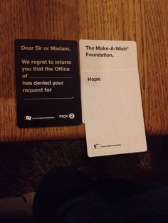 a piece of paper sitting on top of a wooden table next to a black and white sign