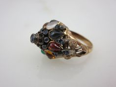 "A lovely vintage 18k gold and multi stone ring, featuring mainly sapphires. The style is known as a Thai Princess ring, with it's gemstone studded pointy top. Marked \"18k\". US size 5.5 and is resizable at any jeweler. Actual packaging will vary depending on item/s purchased and tape pattern available. Props shown in photos is for display purposes only, not included in this listing. As always, satisfaction is guaranteed. Thanks for shopping Vintage In Bloom More rings: http://www.etsy.com/shop Antique Multi-stone Yellow Gold Cluster Ring, Antique Multi-stone Cluster Ring In Yellow Gold, Antique Oval Multi-stone Ring, Victorian Multi-stone Ring For Anniversary, Vintage Multi-stone Sapphire Ring, Vintage Multi-stone Sapphire Wedding Ring, Victorian Multi-stone Cluster Ring For Wedding, Vintage Multi-stone Oval Sapphire Ring, Vintage Gold Multi-stone Cluster Ring