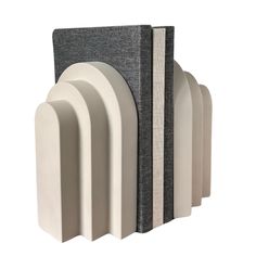 four white and grey bookends with books on each one's back side