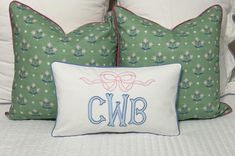 two pillows with bows and monogrammed letters on them