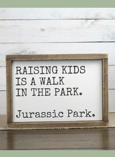 a sign that reads raising kids is a walk in the park, jurasic park