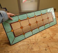 a person holding up a stained glass window