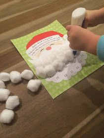 a child is playing with marshmallows to make santa's face on the table