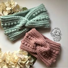 three crocheted headbands with flowers on the bottom and one has a bow at the top