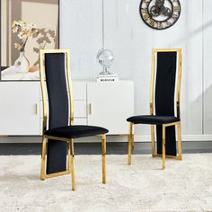 two black and gold chairs sitting in front of a white wall with a clock on it