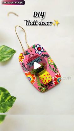 an ornament hanging from a string with flowers and leaves on the bottom of it