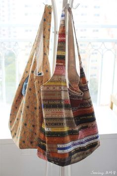 three purses hanging from a hook in front of a window