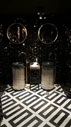 two black and white chairs sitting next to each other in a room with mirrors on the wall