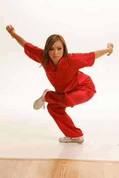 a woman in red jumpsuit doing a dance move