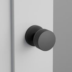 a black knob on the side of a white door