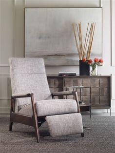 a leather chair sitting in front of a painting