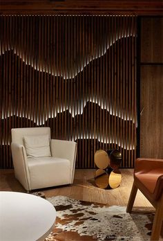 an image of a living room setting with wood slats on the wall and leather chairs