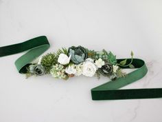 a green ribbon with white flowers and greenery