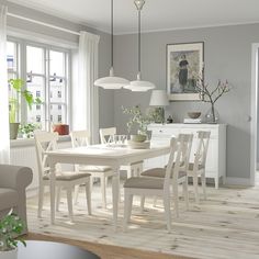 a white dining table and chairs in a room