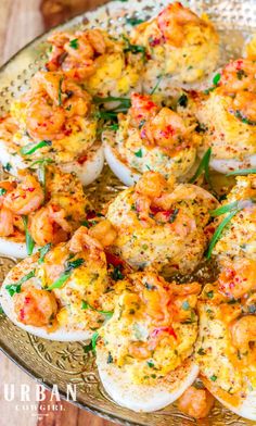 an image of deviled eggs with shrimp and herbs on them in a platter