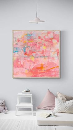 an abstract painting hangs on the wall above a white bed with pink and blue pillows