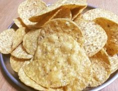 a bowl filled with chips on top of a wooden table